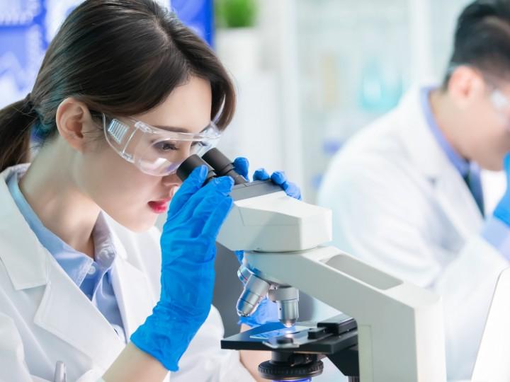 A student looks into microscope during a lab